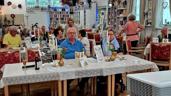 Viele Menschen sitzen an Tischen.