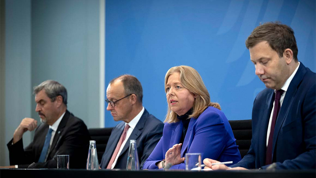 Markus Söder, Friedrich Merz, Bärbel Bas und Lars Klingbeil sitzen nebeneinander an einem Pult. 