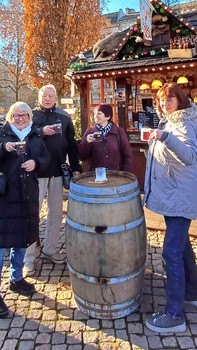 Menschen mit Glühwein am Weihnachtsmarktstand.