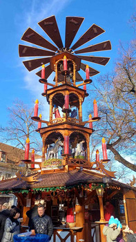 Menschen auf Weihnachtsmarkt vor großer Weihnachtspyramide.
