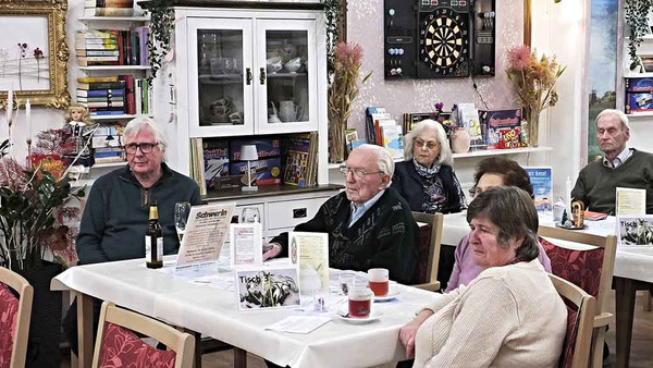 Männer und Frauen sitzen am Tisch