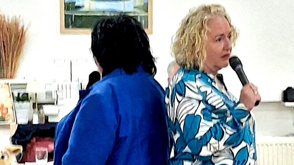 Die Vorsitzenden Doris Seemann vom VdK und Andrea Preuß-Borowsky vom SoVD stehen Rücken an Rücken mit Mikros in der Hand.
