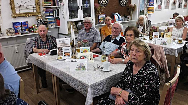 voll besetzter Tisch mit Menschen