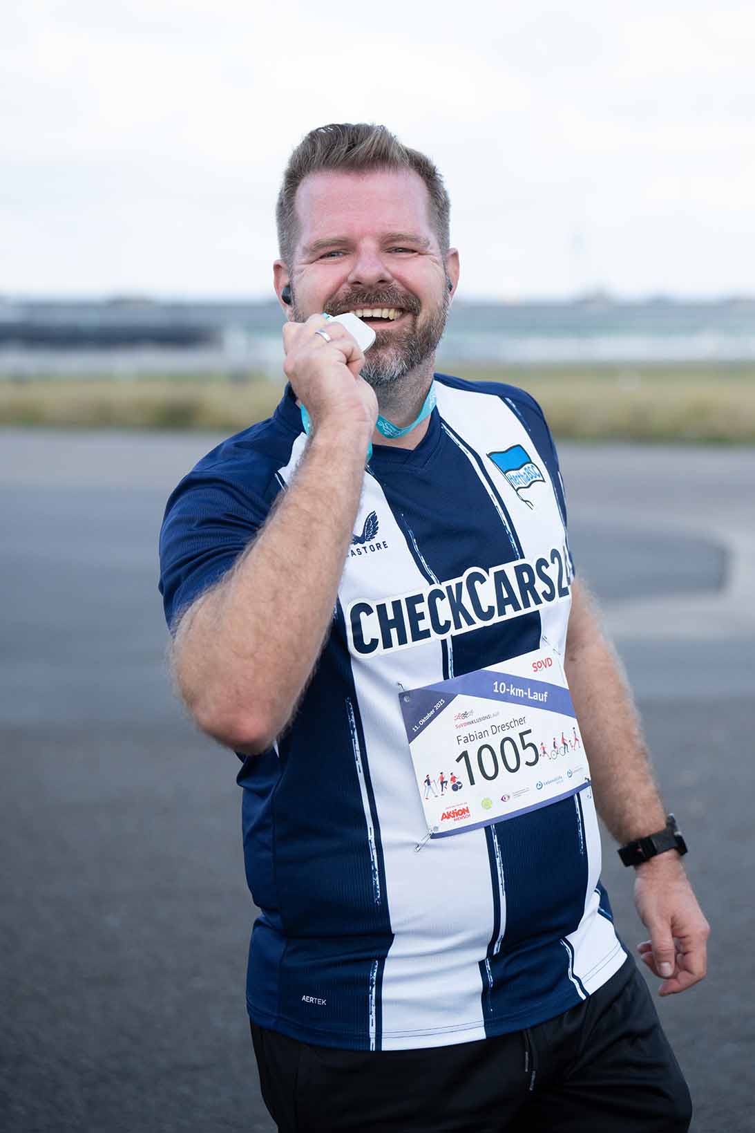 Ein Mann im Hertha-Trikot präsentiert seine Medaille.