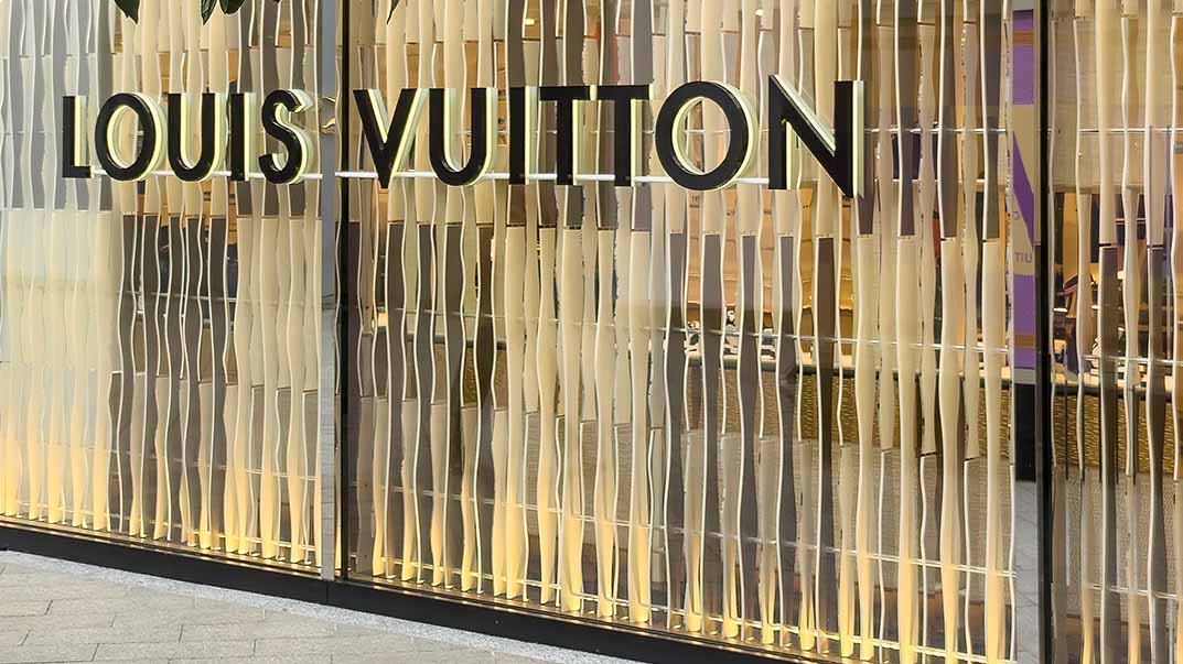Schriftzug "Louis Vitton" an einer Gebäudefassade.