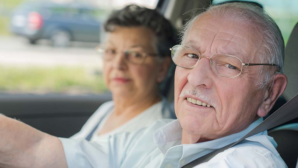Rentnerpaar sitzt im Auto. 
